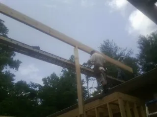 Carpenter setting a ridge beam over a new addition frame — Ice Dam Removal by Roofing Brothers in Webster City