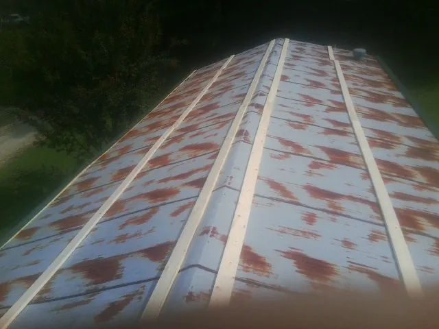 Rusted metal roof panels with new wood purlins before replacement — Storm Damage Roof Repair in Webster City by Roofing Brothers