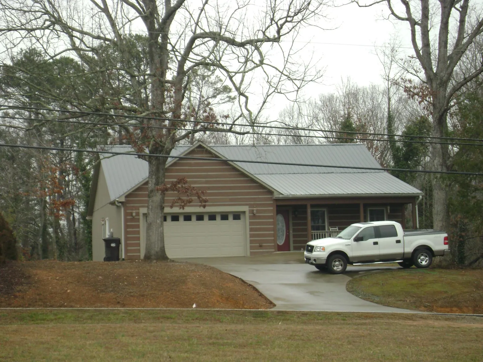 Gray metal roof on a log sided house with an attached two car garage in Webster City